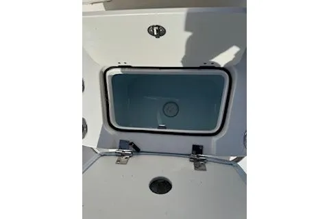 Slide: The Image of 2026 Robalo 206 Cayman boat storage compartment, open lid, white interior. - 15