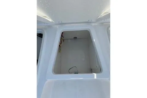 Slide: The Image of 2026 Robalo 206 Cayman boat storage compartment, white interior, open hatch. - 8