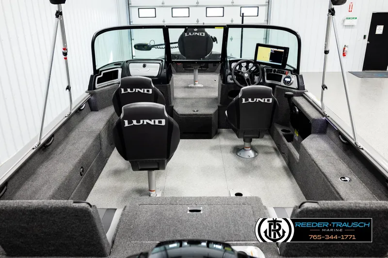 Slide: The Image of 2023 Lund 1875 Impact XS boat interior with seating and control panel in showroom. - 12