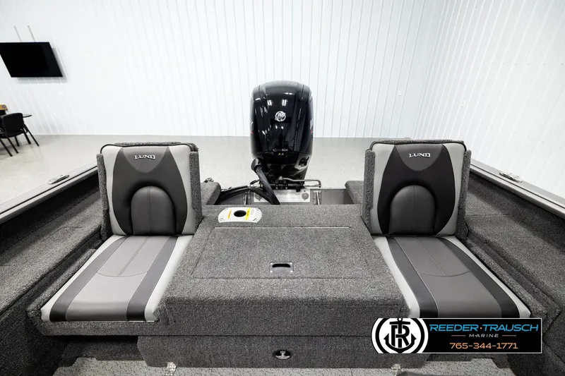 Slide: The Image of 2023 Lund 1875 Impact XS boat interior with dual seats and motor, displayed indoors. - 17