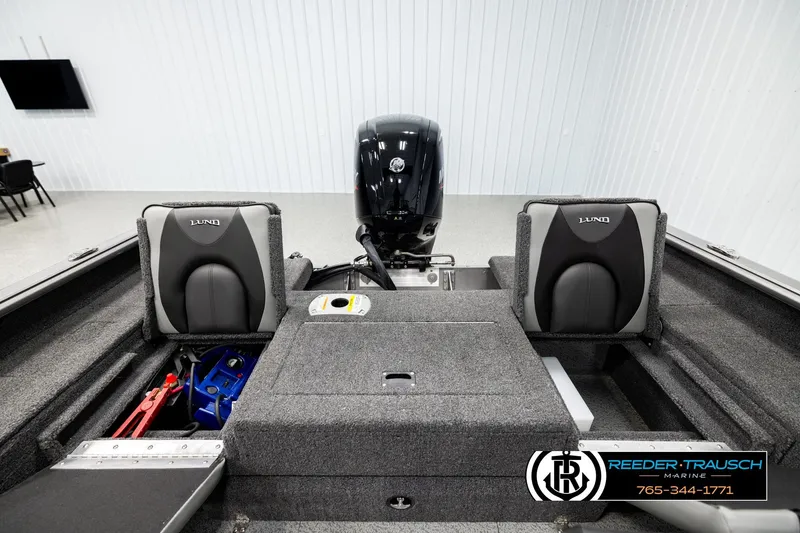 Slide: The Image of 2023 Lund 1875 Impact XS boat interior with seats and motor in showroom. - 18