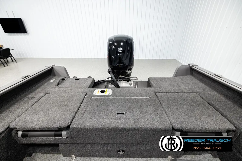 Slide: The Image of 2023 Lund 1875 Impact XS boat interior with motor, displayed in showroom. - 19