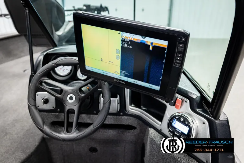 Slide: The Image of 2023 Lund 1875 Impact XS boat dashboard with Garmin display and steering wheel. - 32