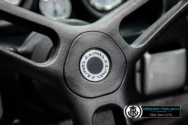 Slide: The Image of Steering wheel of 2023 Lund 1875 Impact XS boat, featuring textured grip and logo. - 34