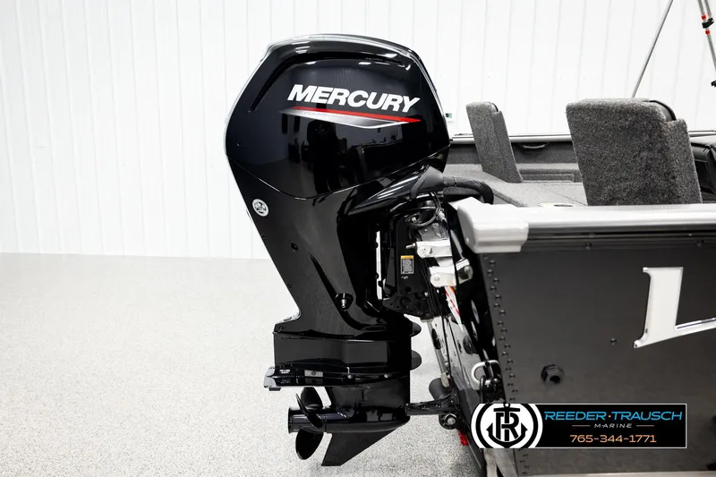 Slide: The Image of 2023 Lund 1875 Impact XS boat with Mercury outboard motor, showcased indoors. - 49