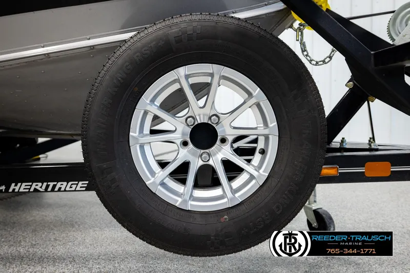 Slide: The Image of 2023 Lund 1875 Impact XS trailer wheel with silver alloy rim, displayed at Reeder-Trausch Marine. - 55