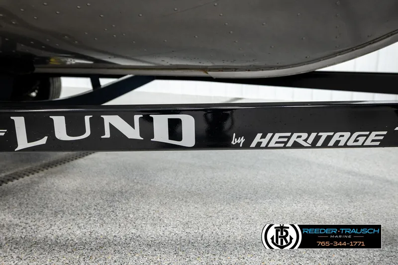 Slide: The Image of 2023 Lund 1875 Impact XS boat trailer by Heritage, Reeder-Trausch Marine branding visible. - 56