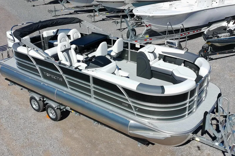 The Image of 2026 Trifecta 24E CS pontoon boat on trailer, featuring sleek design and spacious seating. - 1