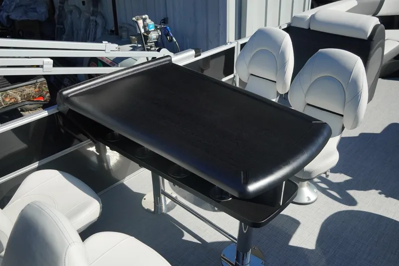Slide: The Image of 2026 Trifecta 24E CS boat interior with sleek black table and white seating. - 21
