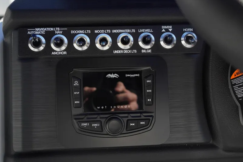 Slide: The Image of Control panel of 2026 Trifecta 24E CS boat with audio system and switches. - 28