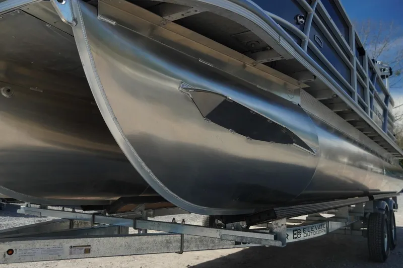 Slide: The Image of 2026 Trifecta 24E CS pontoon boat on trailer, showcasing sleek aluminum design. - 44