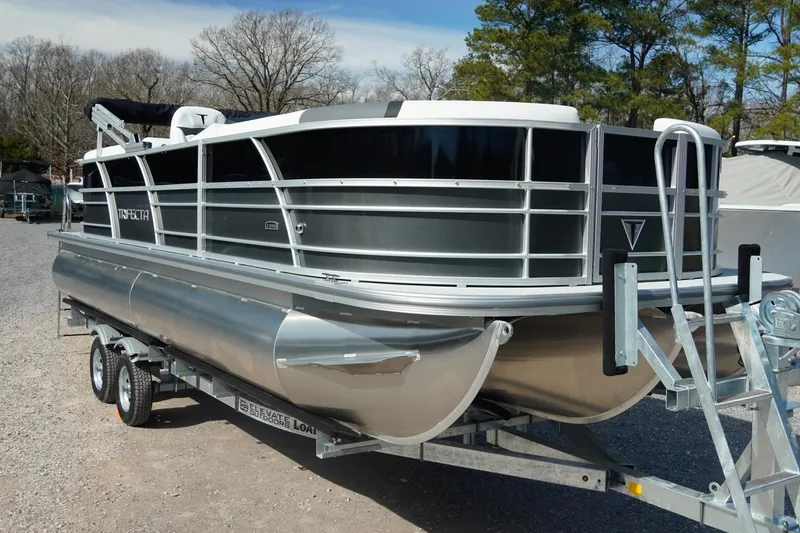 Slide: The Image of 2026 Trifecta 24E CS pontoon boat on trailer, parked outdoors. - 6