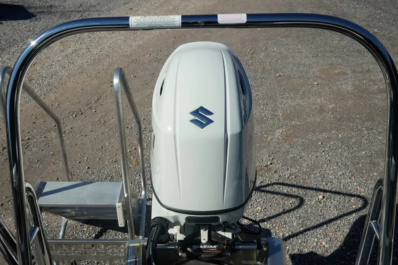 Slide: The Image of 2026 Trifecta 24E CS boat with Suzuki outboard motor on gravel surface. - 9