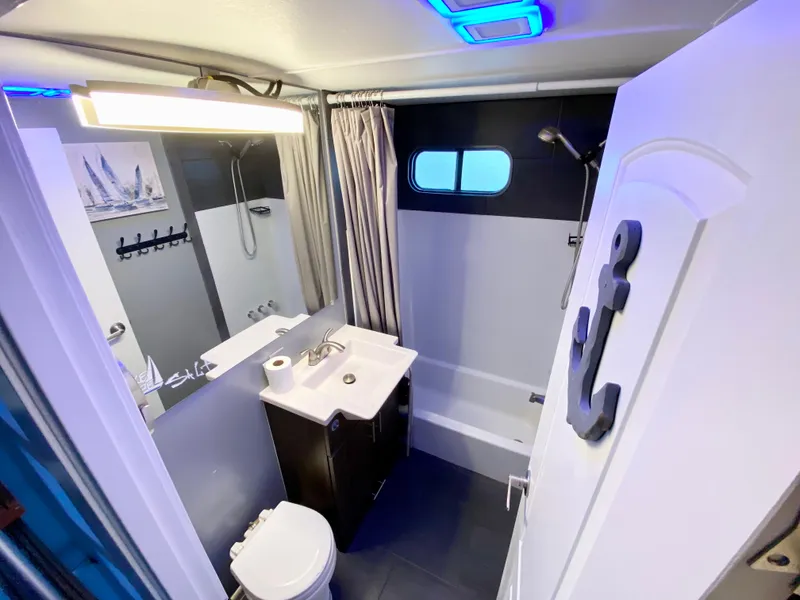 Slide: The Image of Modern bathroom in 1988 Three Buoys 4412 boat with shower, sink, and nautical decor. - 15