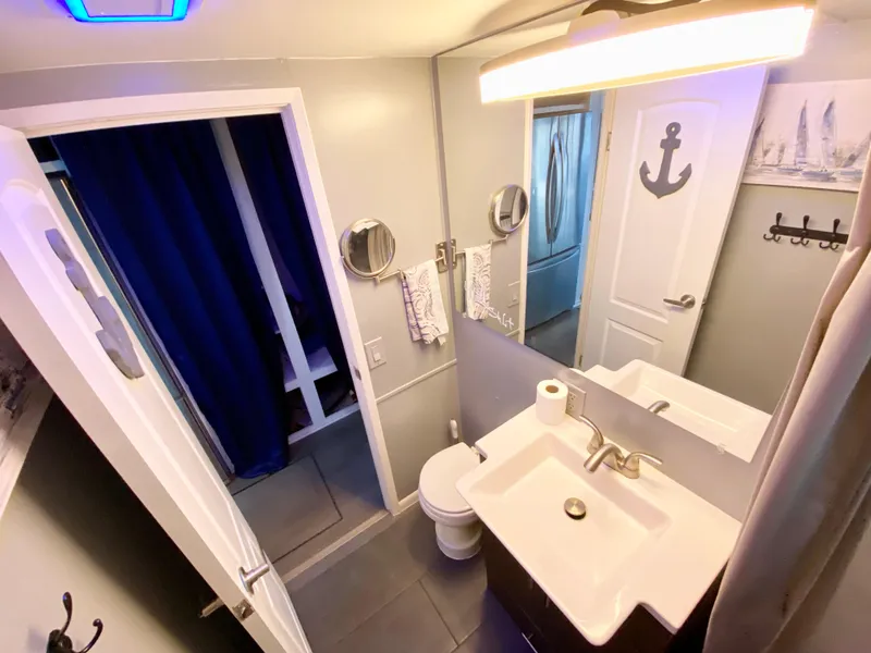 Slide: The Image of Compact bathroom in 1988 Three Buoys 4412 boat, featuring modern fixtures and nautical decor. - 17