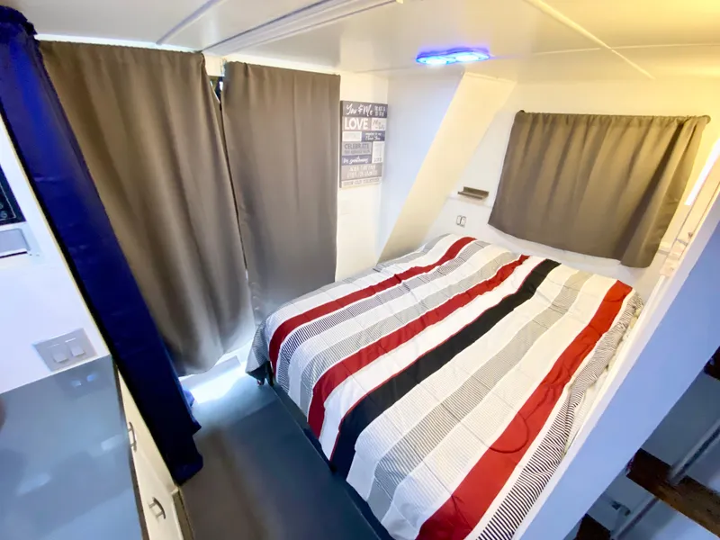 Slide: The Image of Cozy bedroom in 1988 Three Buoys 4412 boat with striped bedding and curtains. - 22