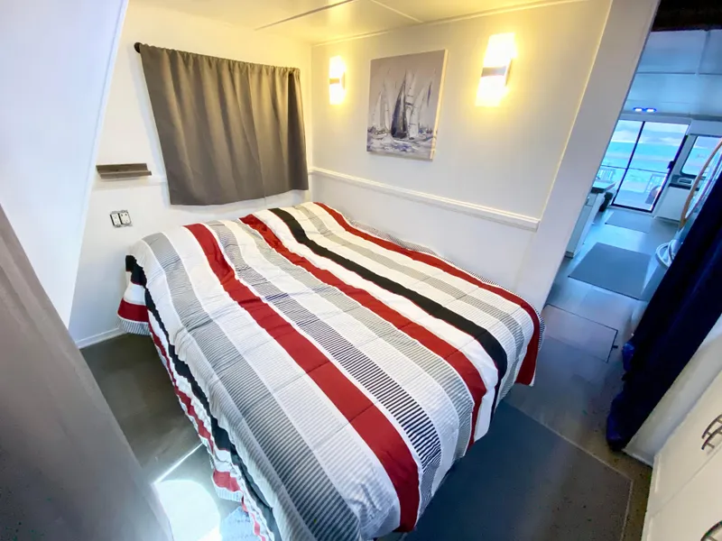 Slide: The Image of Cozy bedroom in 1988 Three Buoys 4412 boat with striped bedding and nautical decor. - 23