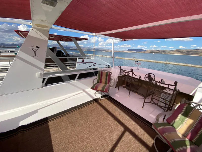 Slide: The Image of 1988 Three Buoys 4412 houseboat deck with seating, lake view, and red canopy. - 30