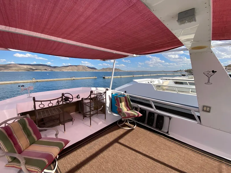 Slide: The Image of 1988 Three Buoys 4412 houseboat deck with seating, lake view, and red canopy. - 31