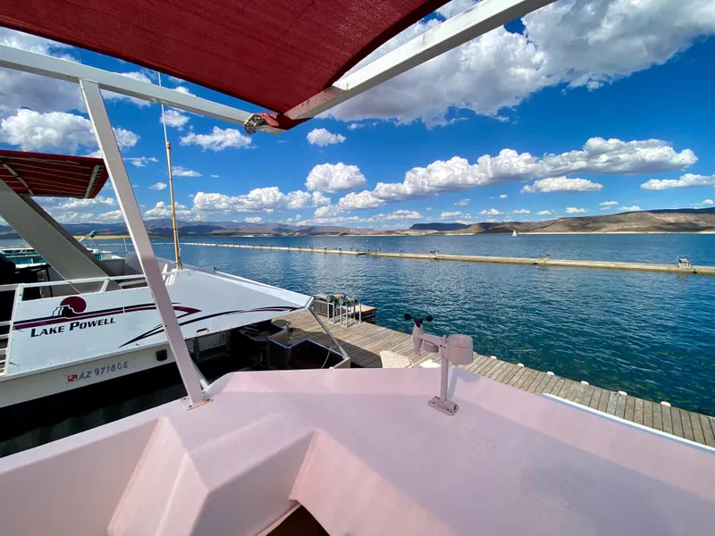 Slide: The Image of 1988 Three Buoys 4412 houseboat docked at Lake Powell under a vibrant blue sky. - 33