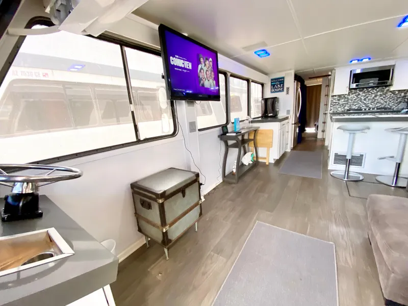 Slide: The Image of 1988 Three Buoys 4412 houseboat docked, featuring upper deck and outboard motor. - 6