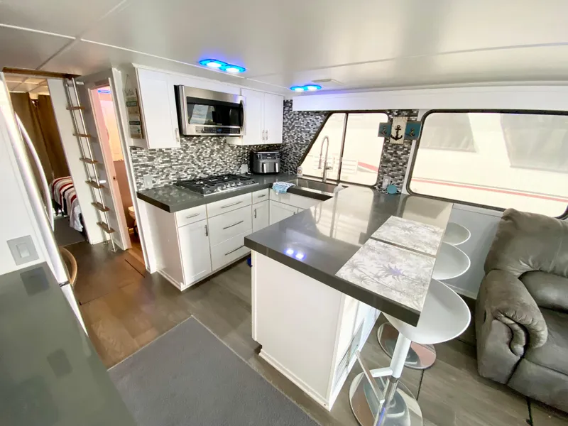 Slide: The Image of Modern kitchen interior of 1988 Three Buoys 4412 houseboat with sleek countertops and seating. - 0