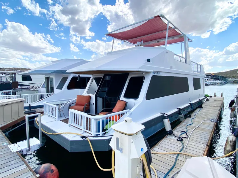 Slide: The Image of 1988 Three Buoys 4412 houseboat docked under a cloudy sky. - 1