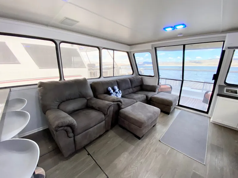 Slide: The Image of Spacious 1988 Three Buoys 4412 houseboat interior with plush seating and large windows. - 10