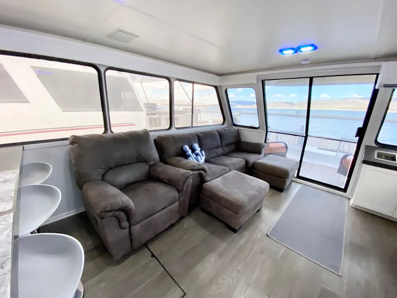 Slide: The Image of Spacious 1988 Three Buoys 4412 houseboat interior with plush seating and large windows. - 13