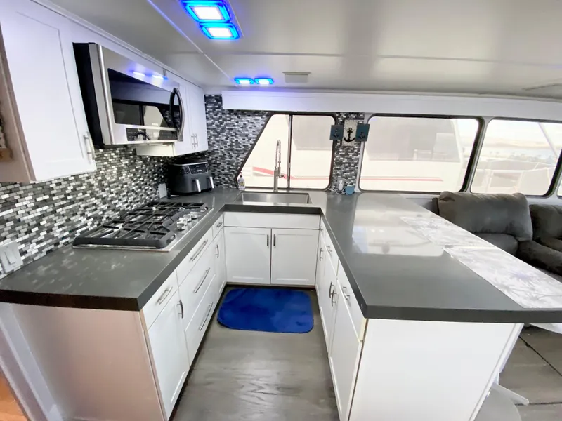 Slide: The Image of Modern kitchen in 1988 Three Buoys 4412 boat with sleek countertops and mosaic backsplash. - 2