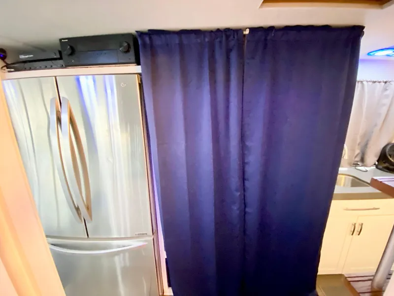 Slide: The Image of 1988 Three Buoys 4412 interior with fridge, blue curtain, and kitchen sink. - 20