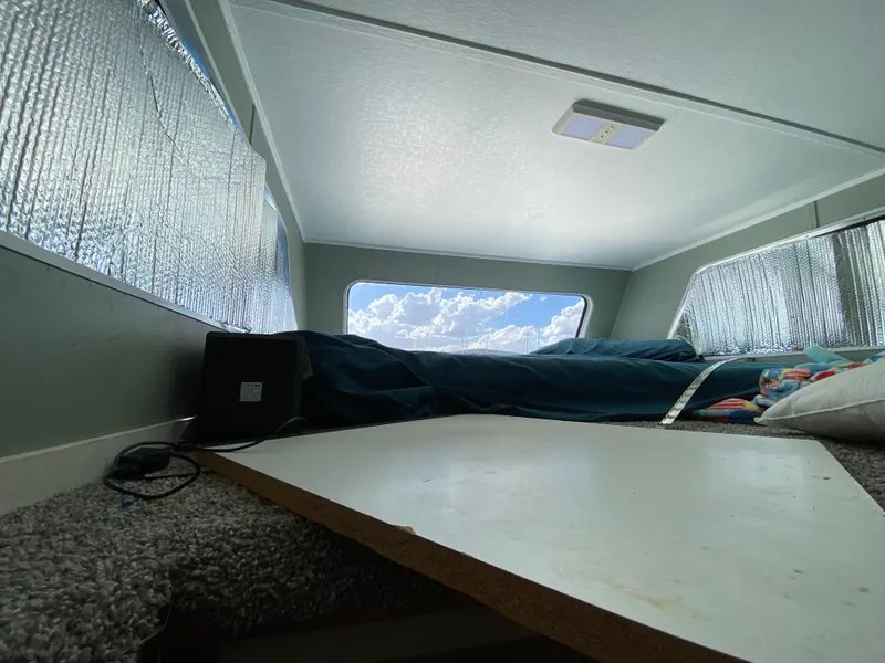 Slide: The Image of Interior of 1988 Three Buoys 4412 houseboat with cozy sleeping area and window view. - 28