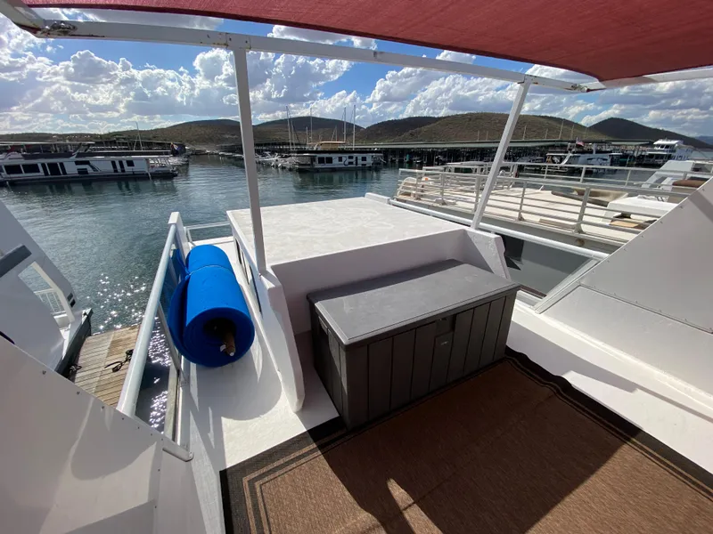 Slide: The Image of 1988 Three Buoys 4412 boat deck with storage box, blue fender, and scenic marina view. - 29