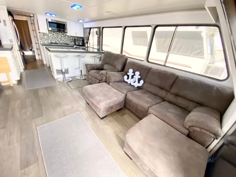 Slide: The Image of Luxurious 1988 Three Buoys 4412 houseboat interior with modern kitchen and cozy seating area. - 4