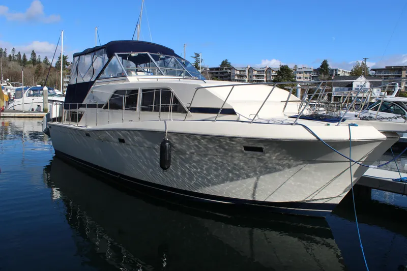 Slide: The Image of 1987 Chris-Craft 381 Catalina yacht docked in a marina under a clear blue sky. - 10