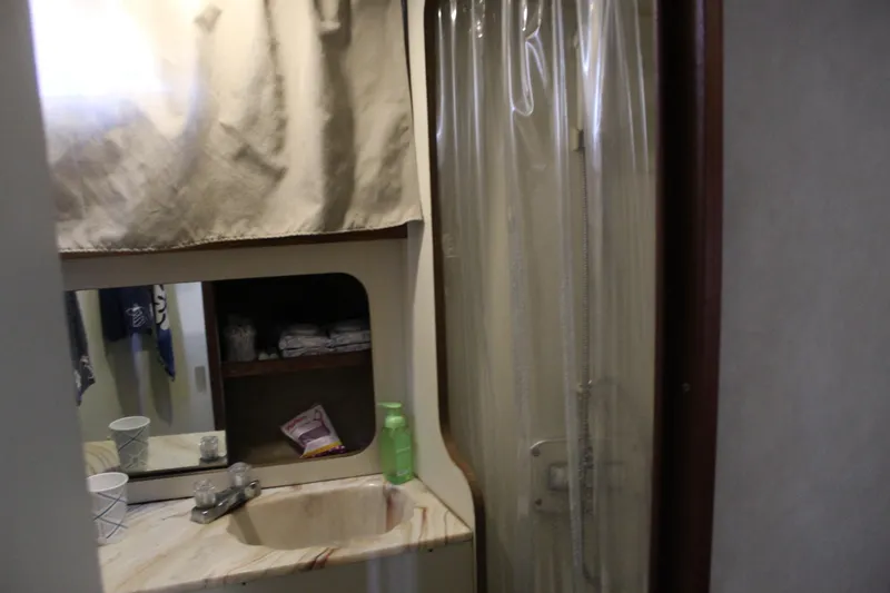 Slide: The Image of 1987 Chris-Craft 381 Catalina bathroom with sink, mirror, and shower curtain. - 18