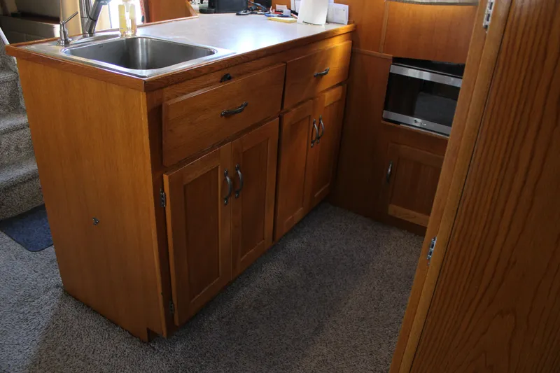 Slide: The Image of 1987 Chris-Craft 381 Catalina kitchen with wooden cabinets and stainless steel sink. - 21