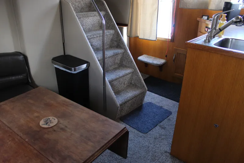 Slide: The Image of 1987 Chris-Craft 381 Catalina interior with stairs, table, and kitchenette. - 23