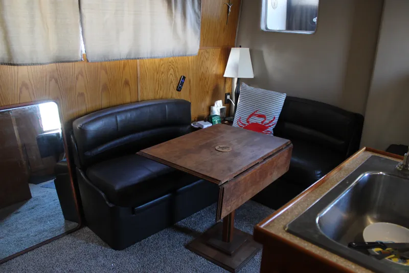 Slide: The Image of 1987 Chris-Craft 381 Catalina interior with cozy seating, wooden table, and nautical decor. - 26