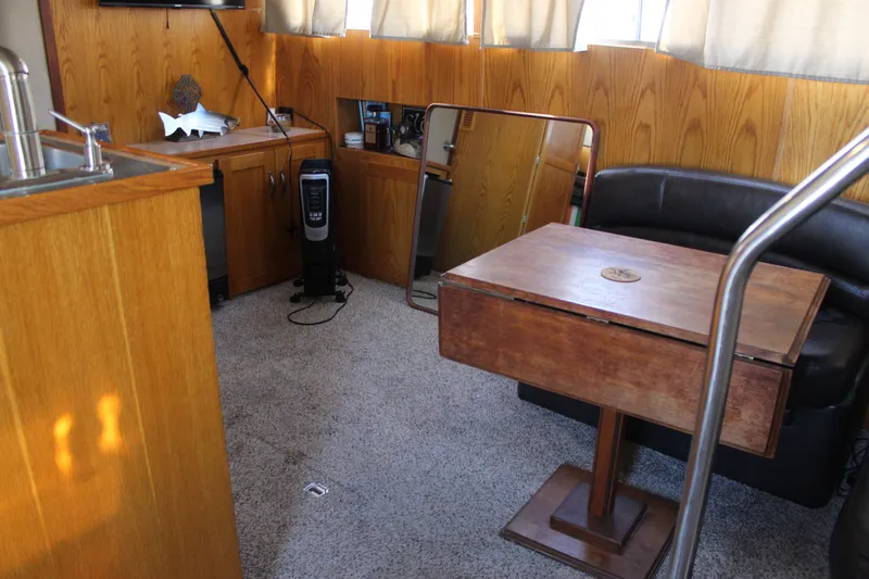 Slide: The Image of Interior of 1987 Chris-Craft 381 Catalina with wood paneling and cozy seating area. - 27