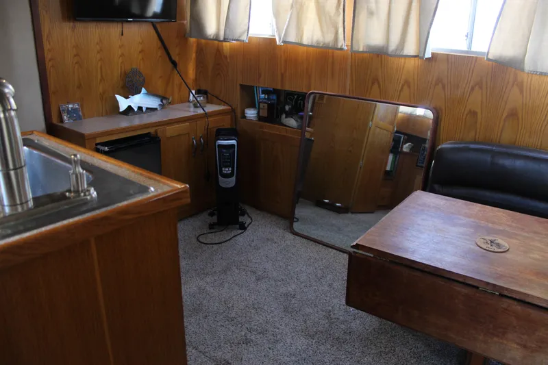 Slide: The Image of 1987 Chris-Craft 381 Catalina interior with wood paneling, sink, and table. - 29