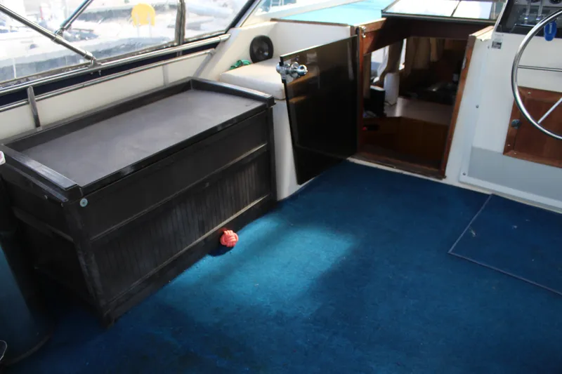 Slide: The Image of 1987 Chris-Craft 381 Catalina interior with blue carpet and storage bench. - 7