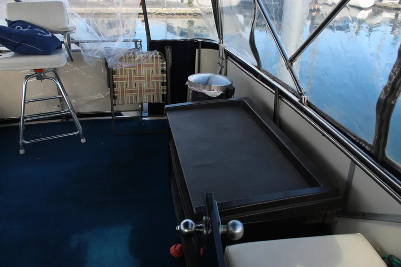 Slide: The Image of 1987 Chris-Craft 381 Catalina boat interior with seating and table, docked by the water. - 8