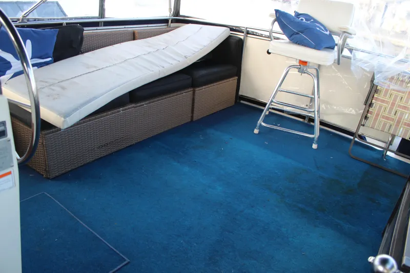 Slide: The Image of 1987 Chris-Craft 381 Catalina interior with blue carpet, wicker seating, and a captain's chair. - 9