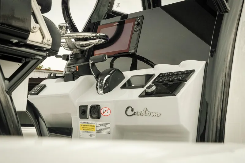 Slide: The Image of 2026 Tidewater 2500 Carolina Bay boat dashboard with steering wheel and control panel. - 13