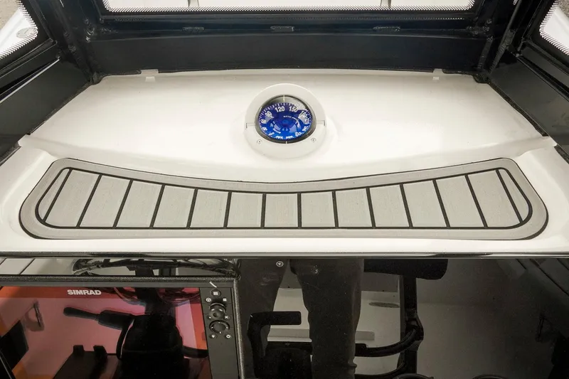 Slide: The Image of 2026 Tidewater 2500 Carolina Bay dashboard with compass and Simrad display. - 47