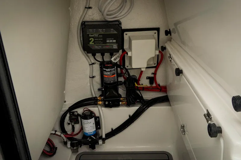Slide: The Image of Electrical and plumbing components inside a 2026 Tidewater 2500 Carolina Bay boat. - 51