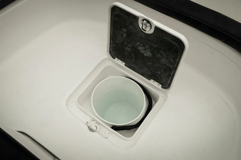 Slide: The Image of 2026 Tidewater 2500 Carolina Bay boat storage compartment with open hatch and bucket. - 55