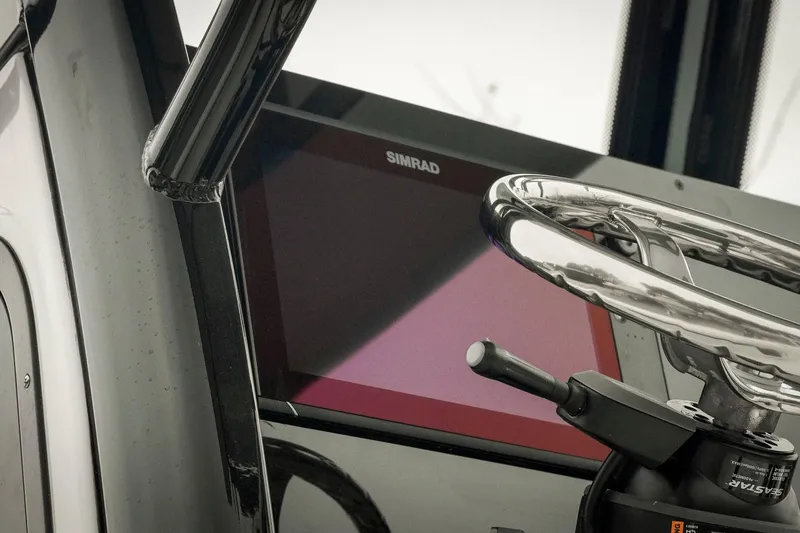 Slide: The Image of 2026 Tidewater 2500 Carolina Bay boat helm with Simrad display and steering wheel. - 63