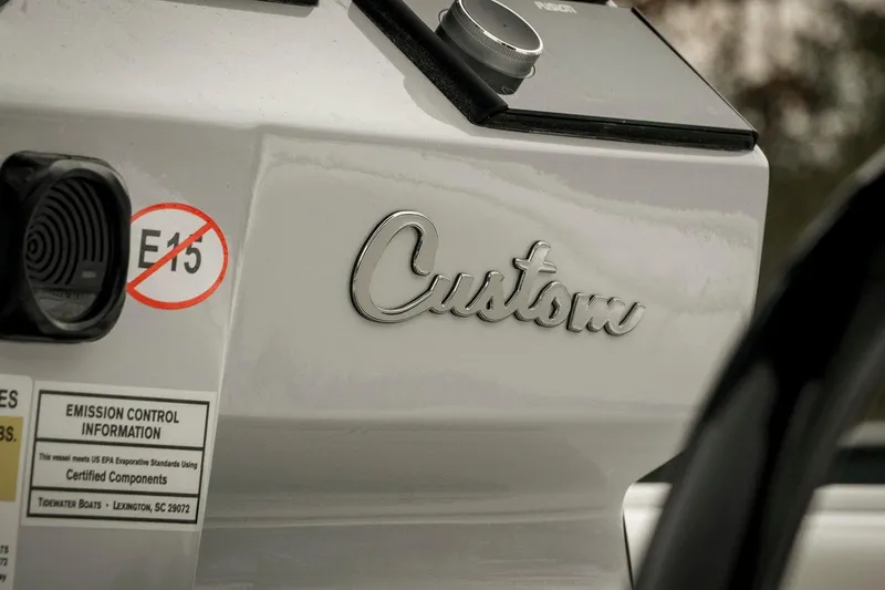 Slide: The Image of 2026 Tidewater 2500 Carolina Bay boat with "Custom" emblem and E15 fuel warning. - 64